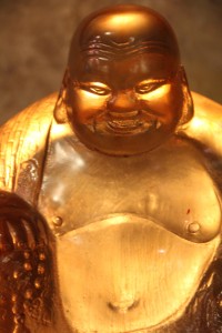 Seated Buddha figure in translucent amber resin; back lit